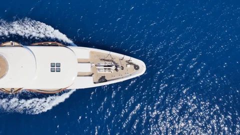 Superyacht bow cutting through blue sea